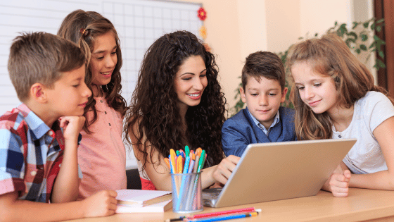 School students and teacher using laptop